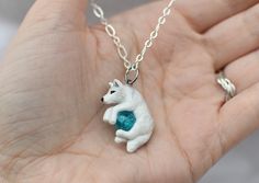 "A perfect gift for yourself or the wolf lover in your life! This dashing double sided white wolf was hand sculpted from polymer clay and painted with acrylic paints and metallic rub, then finished with a durable sealant. From ear to tail the wolf measures approximately 1 inch Included is a crackled bead of your color choice, gem \"N\" is the color shown with the wolf in the example photos. **NOTE** Your order is made to order and is unique, I will usually have your item made and in the mail wit Whimsical White Resin Jewelry, Hand Painted White Polymer Clay Jewelry, Hand Painted White Clay Jewelry, White Clay Jewelry As A Gift, Personalized White Polymer Clay Jewelry, Wolf Necklace, White Wolf, Colored Gems, The Wolf