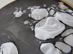 an embroidery project with white and black animal paw prints on it's fabric backing