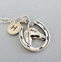 "A horse lovers necklace... This detailed solid sterling silver horse/horseshoe charm dangles from a sterling silver chain. A small round tag/charm sways alongside with a hand stamped initial. The horse/horseshoe charm measures 20 x 13.5mm (13/16\" x 9/16\") and the small hand stamped initial tag measures 9mm (3/8\"). The chain comes in a (14\", child\"s length), 16\", 18\" and 20\" inch lengths to choose from during checkout. If you have any questions, please do not hesitate to contact me. Than Adjustable Sterling Silver Horse Design Jewelry, Silver Horseshoe Charms Jewelry, Silver Sterling Silver Jewelry For Shows, Silver Horseshoe Jewelry Gift, Silver Horseshoe Necklace For Gift, Nickel-free Horseshoe Sterling Silver Jewelry, Nickel-free Silver Horseshoe Jewelry, Silver Jewelry With Horse Design In Round Pendant, Personalized Silver Horseshoe Jewelry