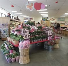 a store filled with lots of flowers and baskets full of gifts on the floor next to each other