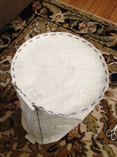 a round white table sitting on top of a rug next to scissors and other items