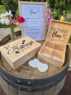 an open wooden box sitting on top of a barrel next to a sign that says tattoo bar