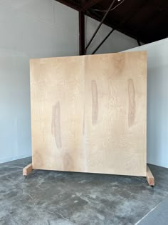 a large piece of plywood sitting on top of a cement floor next to a white wall