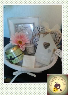 a white basket filled with lots of items and a pink flower on top of it