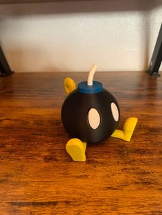 a black and yellow toy sitting on top of a wooden table