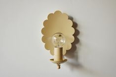 a light that is on the wall with a bulb in it's center and an object behind it