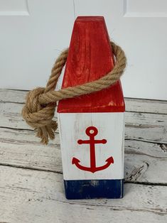 a red, white and blue wooden block with an anchor on it's side