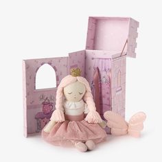 a doll sitting in front of a pink castle