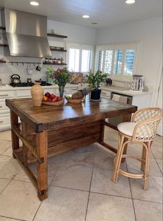 a kitchen with a large wooden table surrounded by chairs