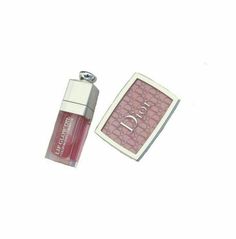 a bottle of lipstick next to a small card holder on a white background with the word dior printed on it