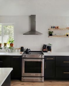 a kitchen with black cabinets and stainless steel appliances