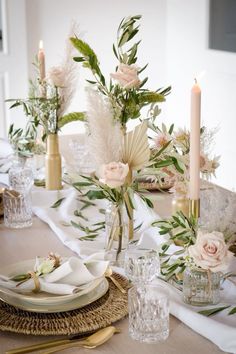 the table is set with flowers, candles and place settings for an elegant dinner party