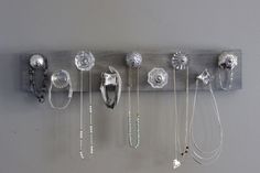 a wall mounted jewelry holder with many different necklaces hanging from it's sides