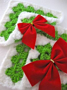 two crocheted bows are sitting on top of each other in green and white