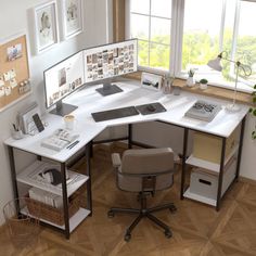 an office desk with two computer screens on top of it and a plant in the corner