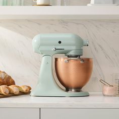 a blue mixer sitting on top of a counter next to some croissants