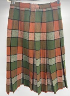 Vintage 100% Wool Plaid Pleated Skirt W/Union Tag Green/Orange  This vintage wool skirt comes in good used condition, with little signs of use and wear. This skirt does not have a size tag and measure approximately 11.5" across the waist, 26" from top to bottom. Please see photos as they are part of the description and exact condition details. Thank you for looking.