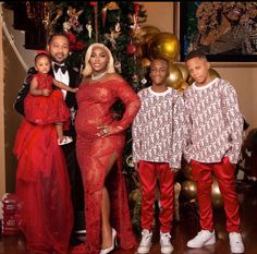 the family poses for a photo in front of a christmas tree