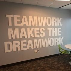 an office break room with a large sign on the wall that says teamwork makes the dream work