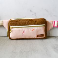 A sassy pink fanny pack with boho-surfer style! The Dawn Patrol Kukui Fanny Pack makes it easy to bring your must-haves with you wherever you go. Compact and practical, it's sure to be your new favorite go-to accessory! Due to the handmade nature and pattern, no two fanny packs are the same. Product Details Cotton linen, cotton 3.75" tall x 7" long x 2" deep Interfaced for structure and stability Adjustable cotton webbing strap (36" - 51" circumference) Plastic contoured buckle closure YKK metal Casual Pink Bag With Zipper Pouch, Pink Travel Belt Bag With Zipper Pouch, Pink Belt Bag With Zipper Pouch For Travel, Daily Use Pink Belt Bag With Zipper Pouch, Pink Belt Bag With Zipper For Daily Use, Pink Zipper Pouch Belt Bag For Everyday Use, Pink Belt Bag For Everyday Use, Pink Rectangular Belt Bag For Everyday Use, Rectangular Pink Belt Bag For Everyday Use