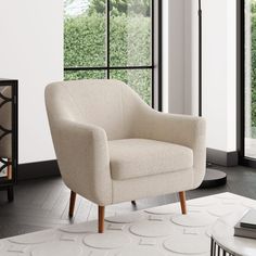 a white chair sitting on top of a rug next to a window