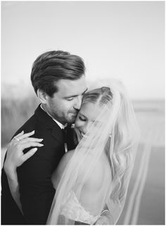 a bride and groom embracing each other in black and white