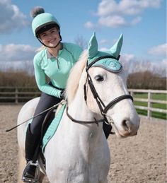 a woman riding on the back of a white horse