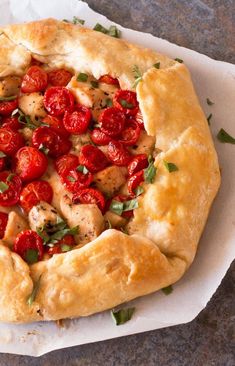 a pizza with tomatoes and chicken on it