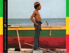 a man standing in front of a boat on the beach