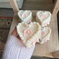 three heart shaped cookies are being held by someone's hand