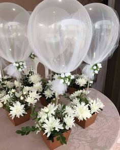 some white flowers and balloons on a table