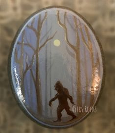 a button with a bigfoot walking in the woods on it's back side