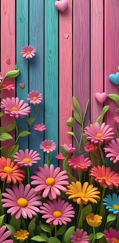 colorful flowers are growing in front of a wooden fence with hearts on it's side