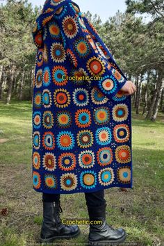 a woman is wearing a blue crocheted blanket with circles on the front and sides