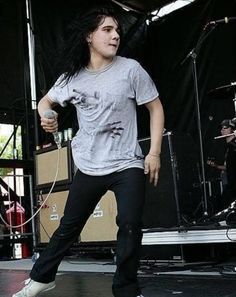 a man standing on top of a stage holding a microphone