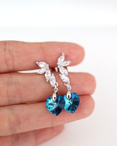 "Peacock Wedding: Bermuda Blue Swarovski Earrings. Blue Bridesmaids Earrings. Handmade Sterling Silver Earrings feature sparkly Bermuda Blue Swarovski hearts. These beautiful earrings are made of Crystallized Swarovski Elements that hang from Sterling post earrings with clear Cubic Zirconia flower. They are perfect for a fancy night. The colors will catch everybody's eyes and gorgeous as focal point of your outfit. Also great for Bridesmaids sets. Contact me for larger orders. The Swarovski crys Blue Hanging Earrings, Cubic Zirconia Heart Earrings For Wedding, Crystal Heart Earrings For Wedding, Silver Heart Cut Crystal Earrings For Wedding, Elegant Crystal Heart Earrings For Wedding, Crystal Heart Cut Earrings For Wedding, Blue Earrings For Valentine's Day Party, Elegant Heart Crystal Earrings For Weddings, Crystal Dangle Heart Earrings For Wedding