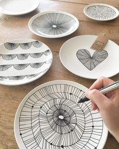 a person is drawing on some plates