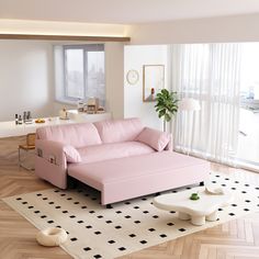 a pink couch sitting on top of a hard wood floor next to a white table