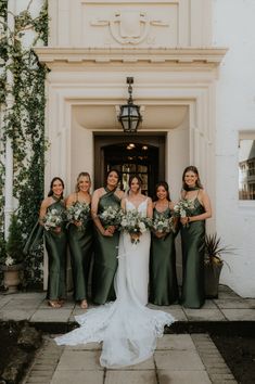 the bride and her bridesmaids pose for a photo in front of their wedding venue