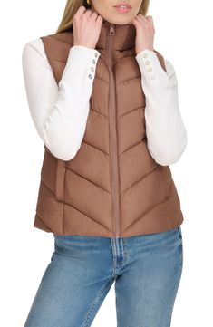 Layer on this channel-quilted puffer vest constructed with a cozy stand collar and convenient front pockets. 23" length Front zip closure Stand collar Front welt pockets Lined, with polyester fill 100% polyester Machine wash, tumble dry Imported American Eagle Puffer Vest, Brown Puffer Vest Women, High Neck Cropped Puffer Vest, Old Navy Puffer Vest, Puffer Vest Tan, Quilted Puffer Vest, Concert Looks, Flip Flop Slippers, Baby Boy Shoes