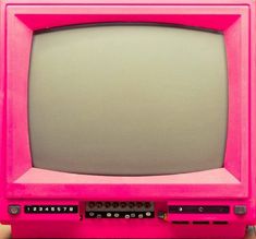 an old pink television sitting on top of a wooden table