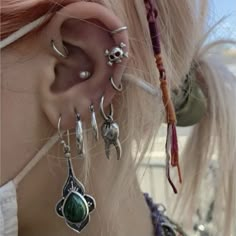 a close up of a person's ear with different types of piercings on it