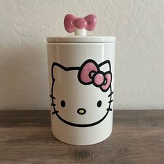 a hello kitty canister with two pink bows on top