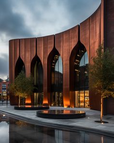 a building with arched windows next to a fountain in front of it at night time