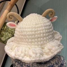 a white crocheted hat with horns and ears