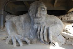 a statue of a man with his hands on his face and feet spread out in front of him