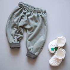 a pair of white shoes next to a baby's pants