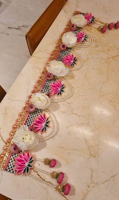 an elaborately decorated table with flowers on the top and bottom, along with other decorative items