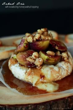 baked brie with roasted figs, honey and walnut topping on a wooden plate