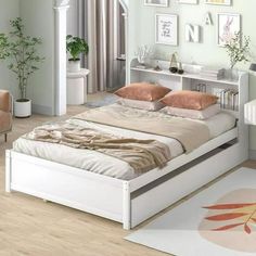 a white bed sitting in a bedroom on top of a hard wood floor